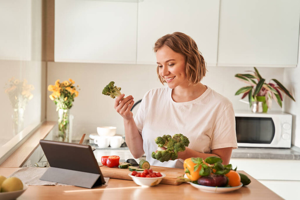 Woman vlogger with broccoli in her hand - Fotoğraf, Görsel