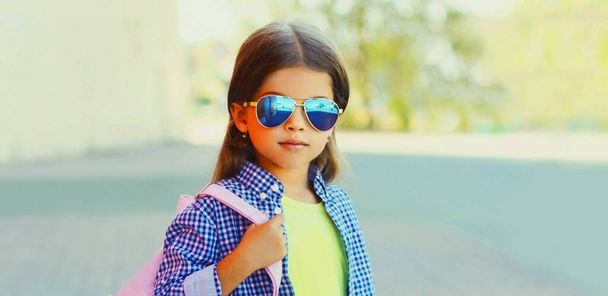 Portrait of stylish little girl child in the city over a pink background - Valokuva, kuva