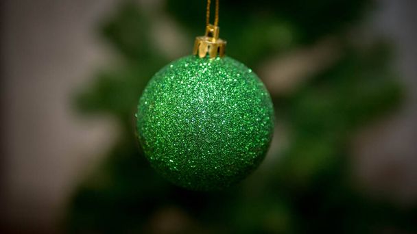 Christmas toy on the tree, Christmas background. Green toy - 写真・画像