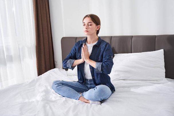 Woman meditating with hands in prayer gesture - Valokuva, kuva