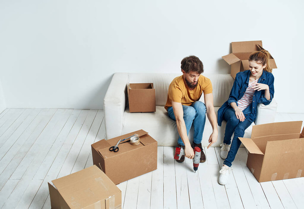молода пара на білому дивані з коробками веселого спілкування
 - Фото, зображення
