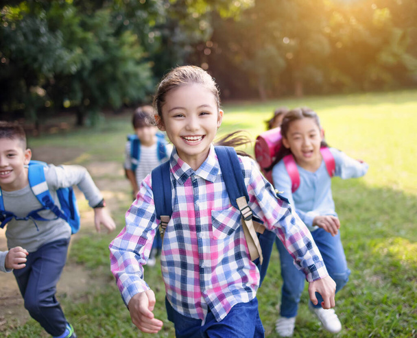 Skupina žáků základních škol běhajících po trávě - Fotografie, Obrázek