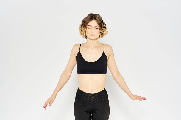 Donna snella in leggings su uno sfondo leggero facendo esercizi di ginnastica fitness - Foto, immagini