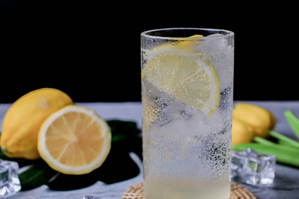 Lemonade. Drink with fresh lemons in fizzy sparkling water, juice refreshment. Lemon cocktail with juice and ice. - Photo, Image