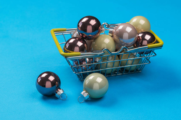 Металева кошик зі скляними кульками для ялинки на синьому фоні
. - Фото, зображення