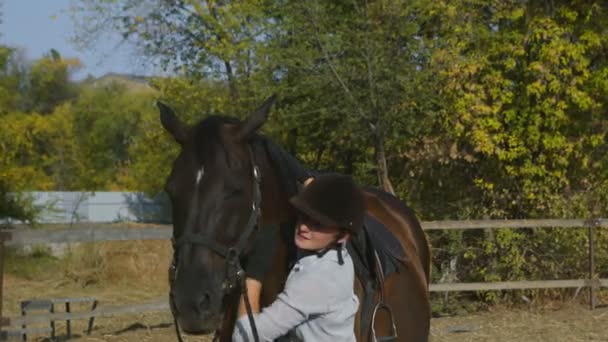 Nainen ratsastaja ratsastus vaatteet ja kypärä silitti hänen hevonen jälkeen ratsastaa - Materiaali, video