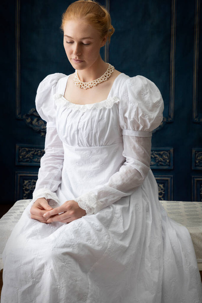 Une femme Régence dans une robe en mousseline blanche debout dans une pièce - Photo, image