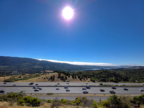 Вид с воздуха на горы и солнце, сияющее над озером с точки зрения панорамы на шоссе 280 - Фото, изображение