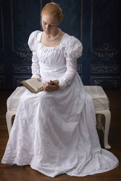 A Regency woman in a white muslin dress standing in a room - Foto, Bild