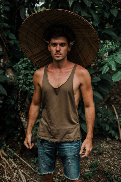 Mies tiellä tropiikissa, olkihattu päässä - Valokuva, kuva
