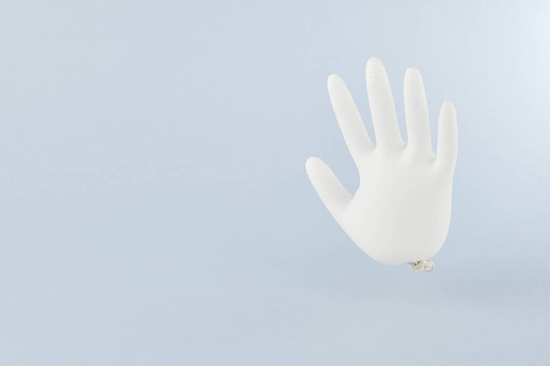 Inflatable medical gloves. Creative minimal concept. Pastel blue background - Фото, зображення