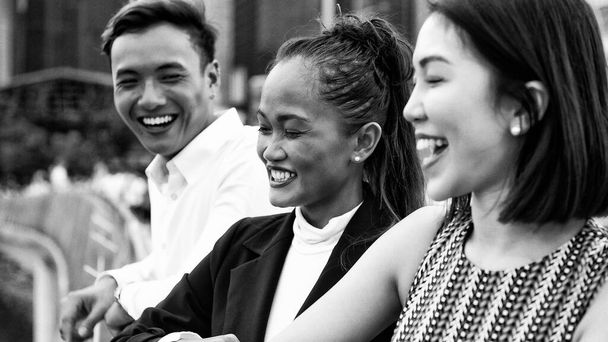 Tre giovani amici asiatici in piedi all'aperto in città a parlare, sorridere e godersi la vita di città. - Foto, immagini