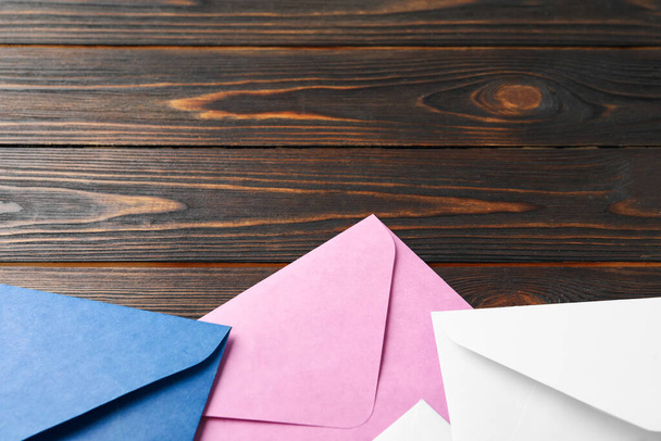 Colorful paper envelopes on wooden background, closeup. Space for text - Fotografie, Obrázek