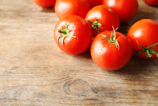 Fresh ripe tomatoes on wooden table, closeup. Space for text - Fotó, kép
