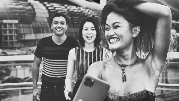 Tři asijské mladé přátele těšit venkovní čas přičemž selfies podél města ulice. - Fotografie, Obrázek