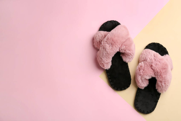 Pair of soft slippers on color background, flat lay. Space for text - Фото, изображение