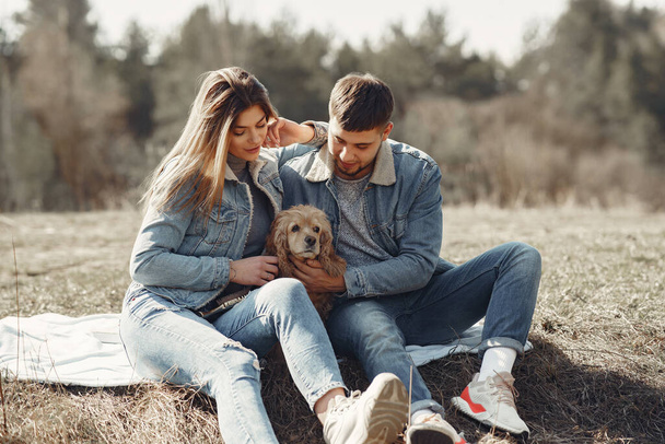 Cute couple in a jeans clothes in a spring field - Zdjęcie, obraz