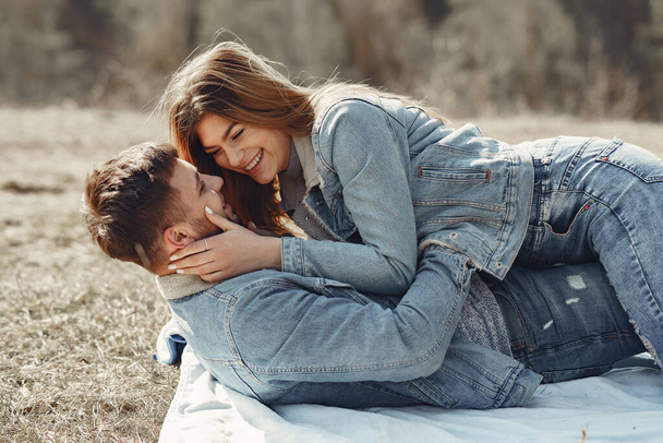 Cute couple in a jeans clothes in a spring field - Foto, Bild