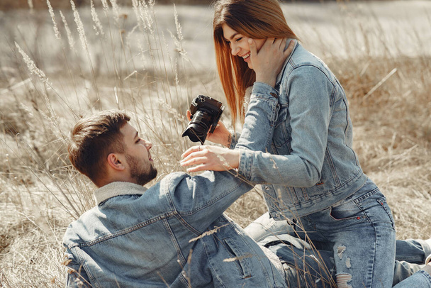Cute couple in a jeans clothes in a spring field - 写真・画像