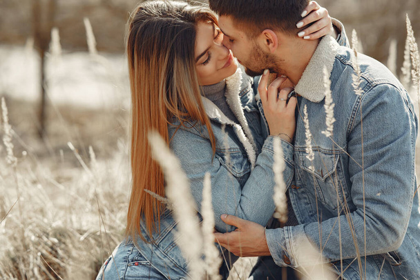 Cute couple in a jeans clothes in a spring field - Fotografie, Obrázek