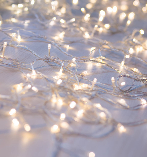 Christmas lights on light background. Decorative garland - Fotó, kép