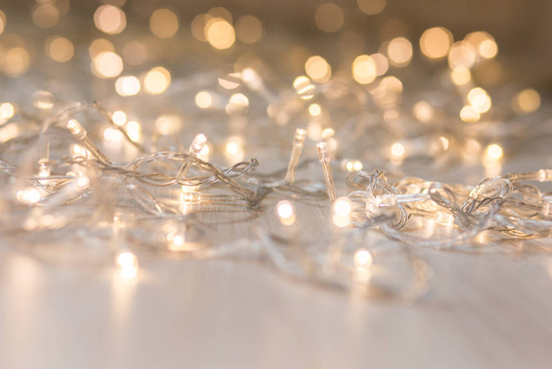 Christmas lights on light background. Decorative garland - Фото, зображення