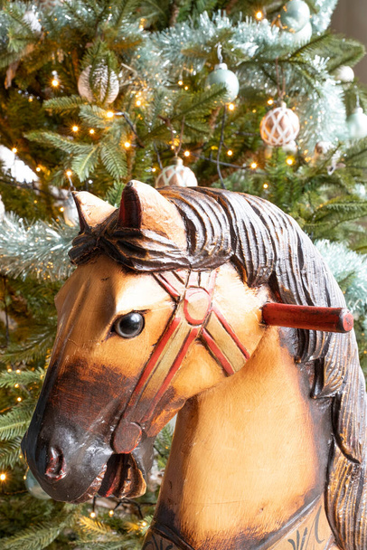 Jolie photo de détail d'un cheval à bascule vintage en bois et d'une partie d'un arbre de Noël. Noël 2020. - Photo, image