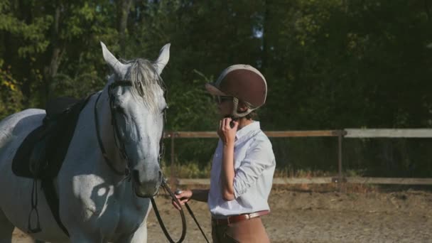 Žena jezdec v jezdeckém oblečení sundá si helmu - Záběry, video