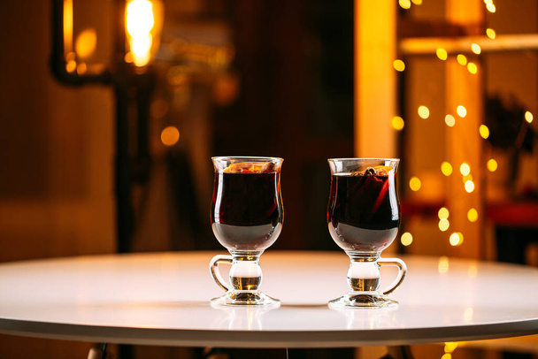 Дві скляні чашки глянцевого вина з розмитими вогнями
 - Фото, зображення