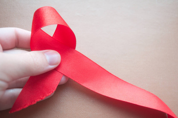 Βοηθάει στην ευαισθητοποίηση, την κόκκινη κορδέλα, την ιδέα της επίγνωσης του HIV, την παγκόσμια ημέρα AIDS. Παγκόσμια Ημέρα Ορφανών του AIDS. Μήνας ενημέρωσης Μαΐου - Φωτογραφία, εικόνα
