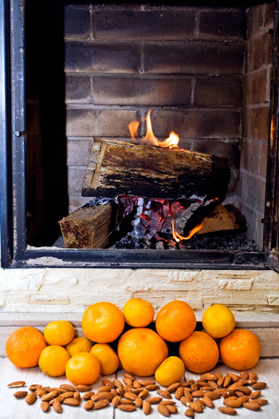oheň v krbu a mandarinky a ořechy - Fotografie, Obrázek
