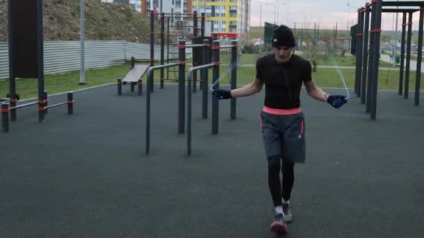 Muž trénuje venku na sportovním hřišti - Záběry, video