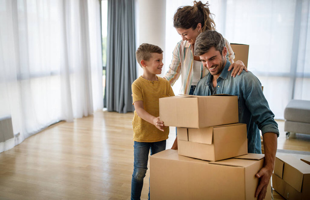 Family unpacking cardboard boxes at new home. New house, family, insurance concept. - Foto, Imagen