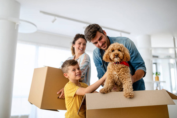 Happy young family with children moving with boxes in a new apartment house. - Photo, Image