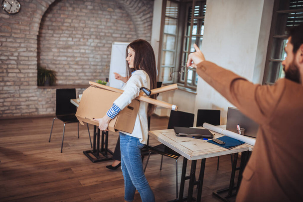 Business woman carrying packing up all his personal belongings and files into a brown cardboard box to resignation in modern office, resign concept. - Foto, Imagen