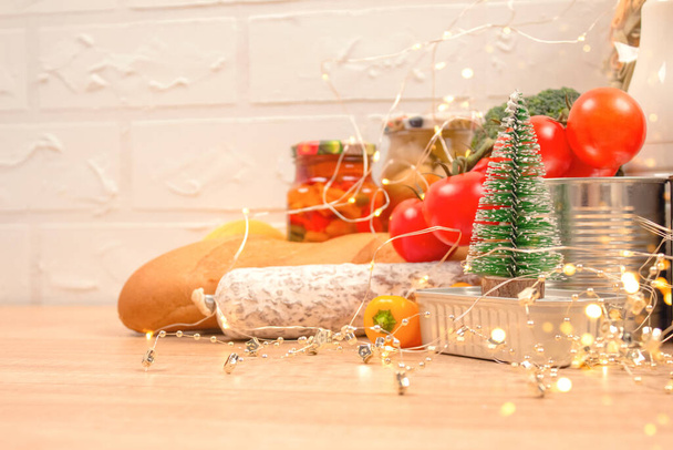 Різдвяні пожертви - пожертвування їжі на світлому тлі з копіспасом - макарони, свіжі овочі, консервовані продукти харчування, багет, кулінарна олія з різдвяними прикрасами. Концепція продовольчого банку або доставки їжі
 - Фото, зображення