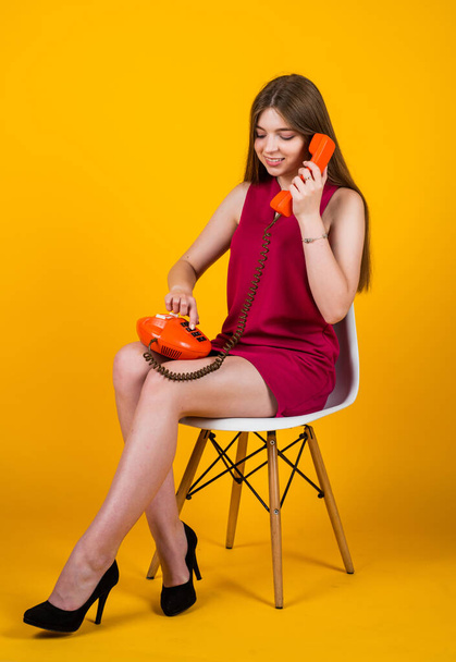 cheerful girl with retro phone. girl dials the phone number. teen kid sit on chair with vintage telephone. old technology in modern life. always stay connected. teen child has conversation - Zdjęcie, obraz