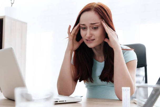 A brunette woman has a headache. - Фото, изображение