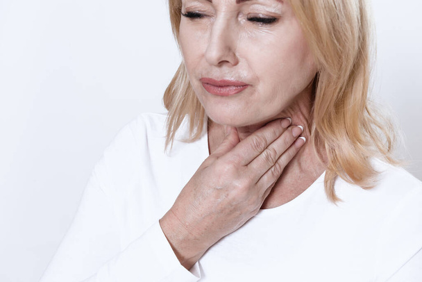 A woman feels severe sore throat and cannot speak. - Φωτογραφία, εικόνα