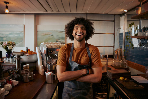 Portrait of confident male barista standing with arms crossed at coffee house - Foto, Imagem