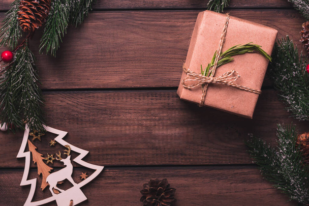Pine branches and christmas gifts on a wooden table, copy space, top view - 写真・画像