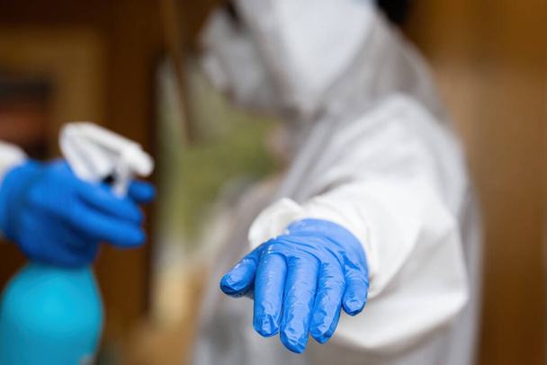 Arzt in voller Schutzkleidung wird während einer Pandemie von einer Krankenschwester desinfiziert. - Foto, Bild