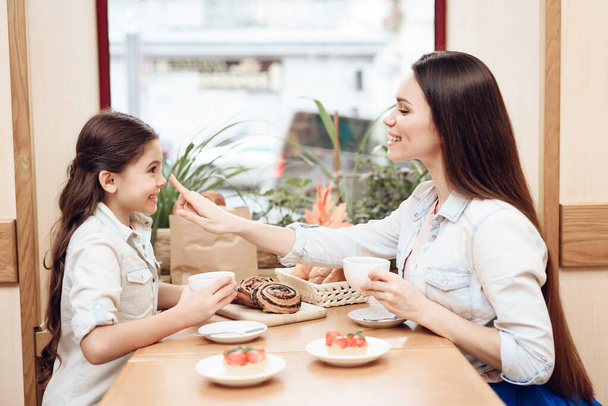 Mutter mit Tochter isst Kuchen in Cafeteria. - Foto, Bild