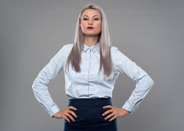 Young successful businesswoman with hands on hips in business suit - Фото, изображение