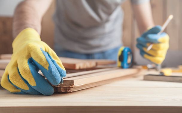 Carpenter making marks on wooden plank with a pencil. - Foto, Bild