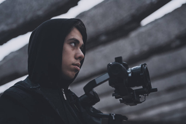 Młodzi profesjonalni kamerzysta filmujący na opuszczonym miejscu - Zdjęcie, obraz