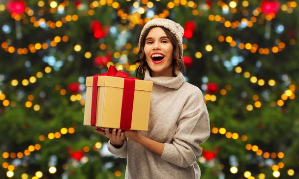 happy young woman holding christmas gift - Фото, зображення