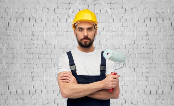 male builder with paint roller over brick wall - Φωτογραφία, εικόνα