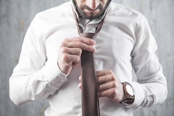 Бизнесмен чинит галстук. Мода, стиль жизни - Фото, изображение