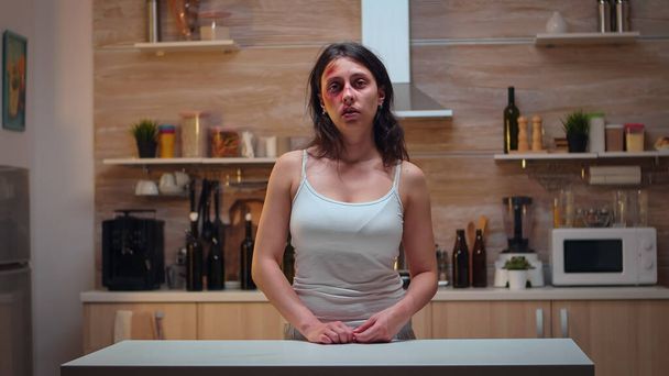 Mujer traumatizada sentada en la cocina - Foto, imagen